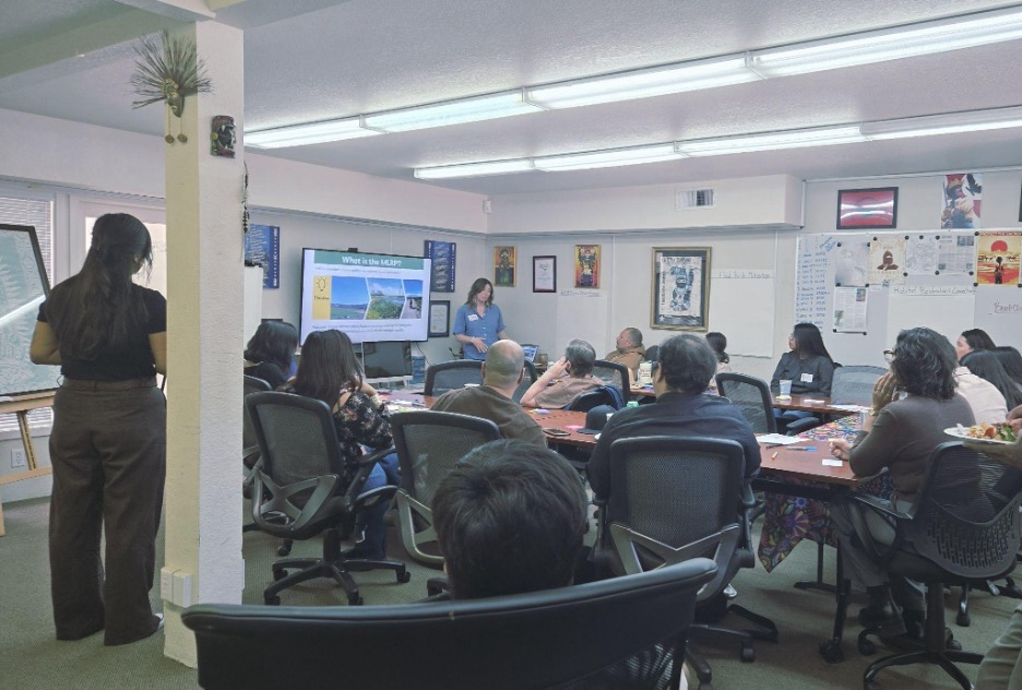 A conference room with people seated at a table